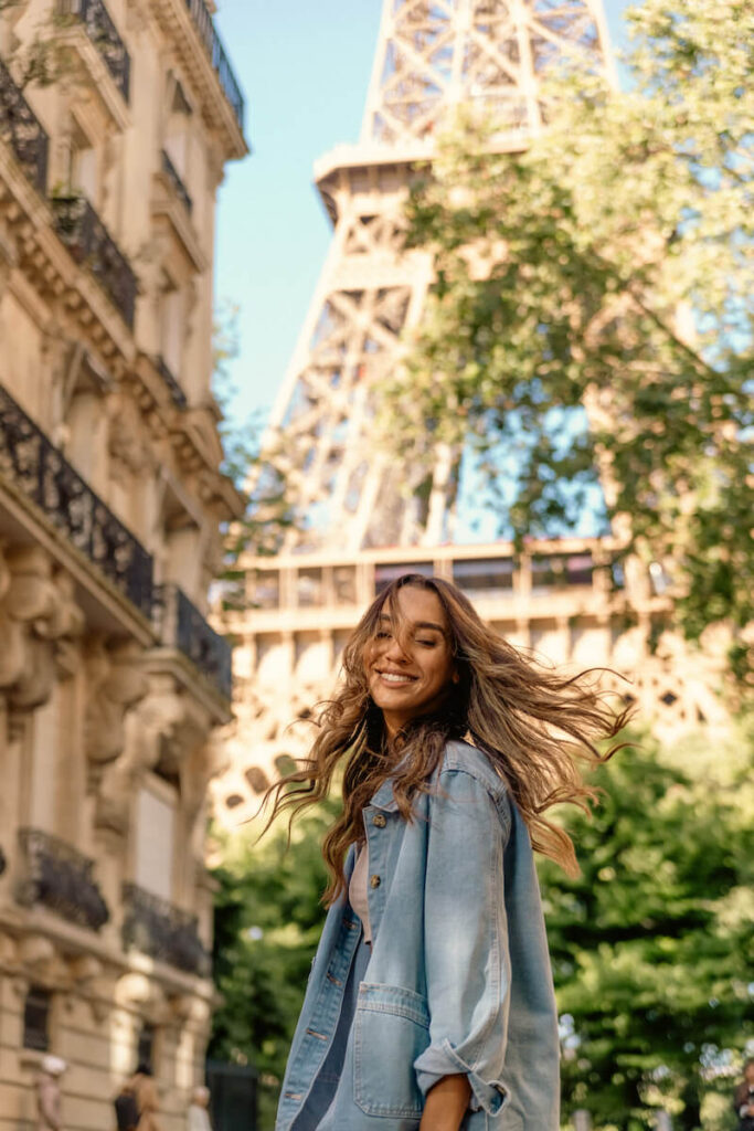 woman laughing in front of eiffel tower blue sky summer