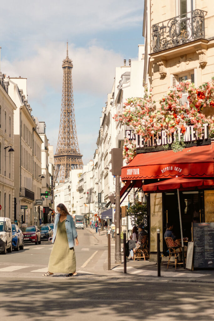 woman walking street on paris street corner Eiffel tower in background cafe flowers
