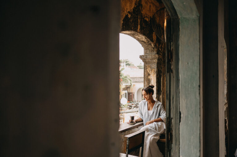 woman drinking cafe on a balcony of old cafe in hoi an