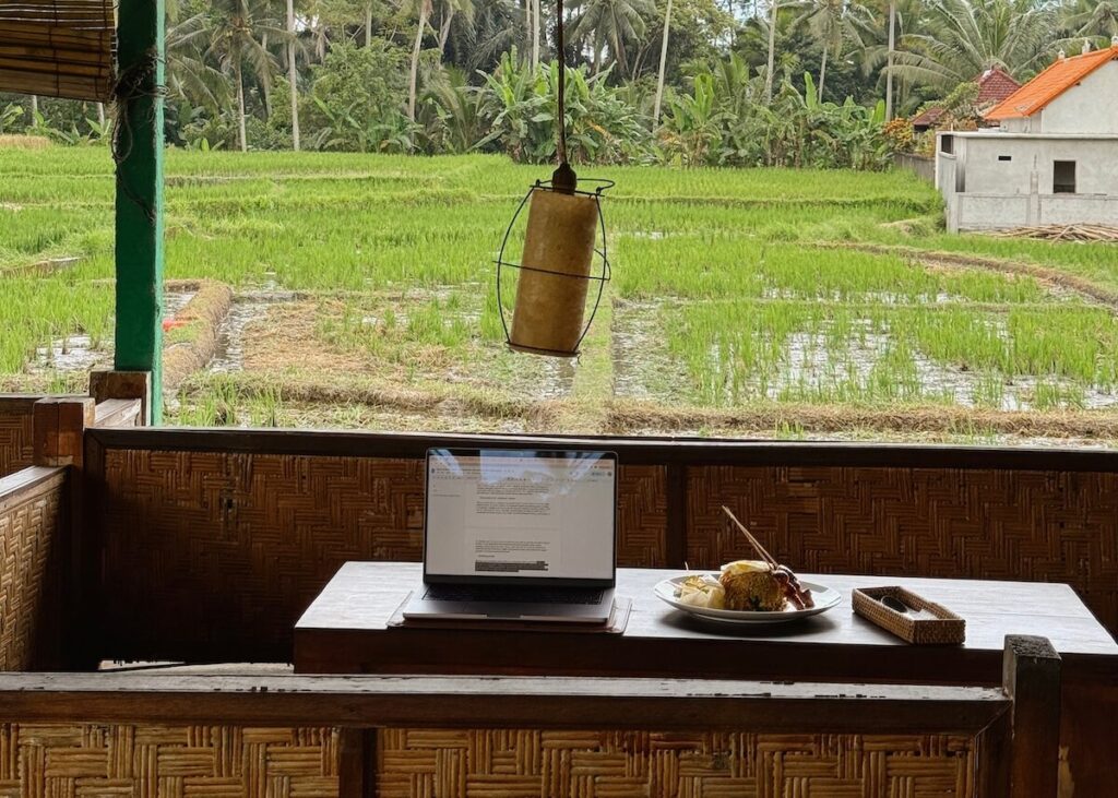 digital nomad working from cafe in Ubud with rice field view
