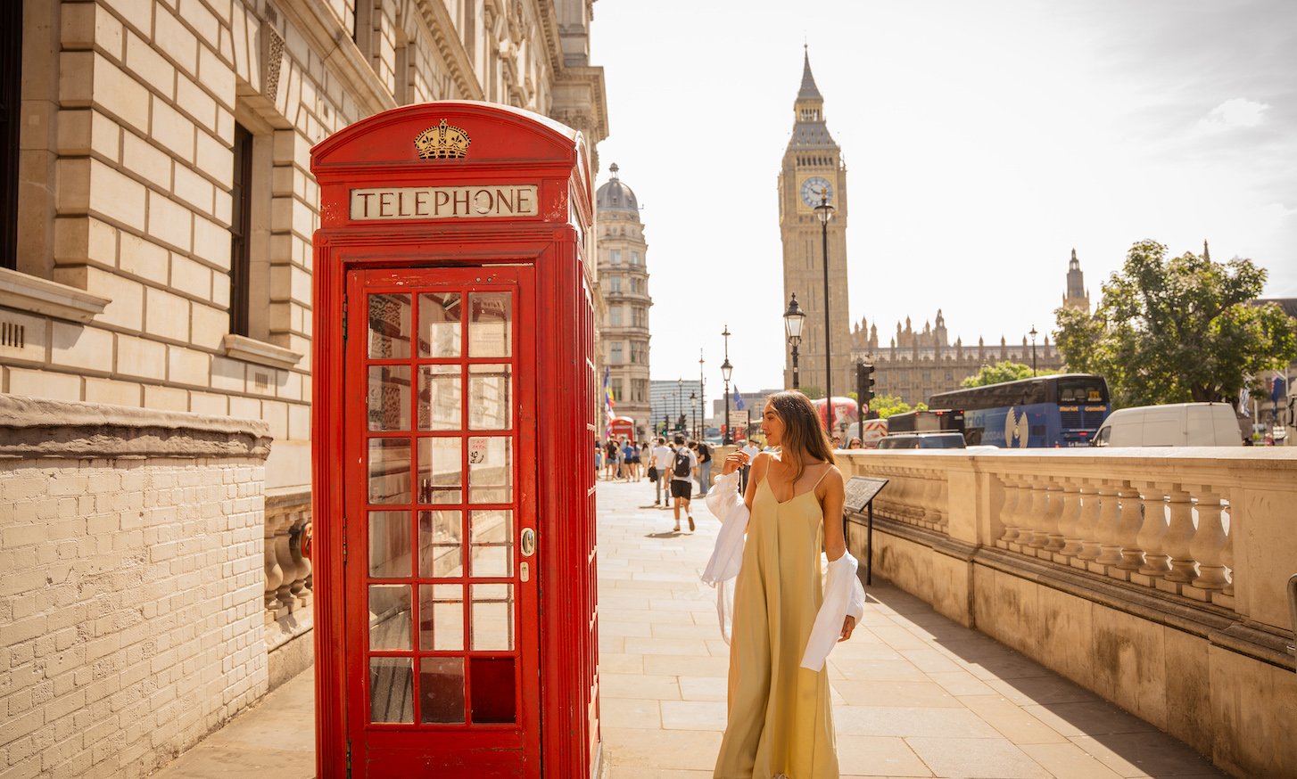 woman in london next to red phone box and big ben in the background